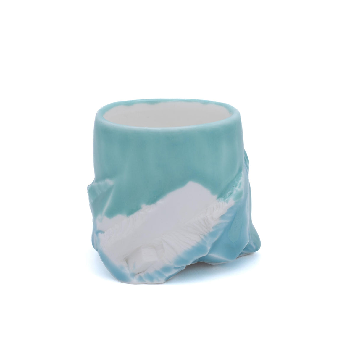 A ceramic cup shaped like a tree stump, featuring a light blue glazed exterior and a white textured bark-like interior, set against a plain white background.