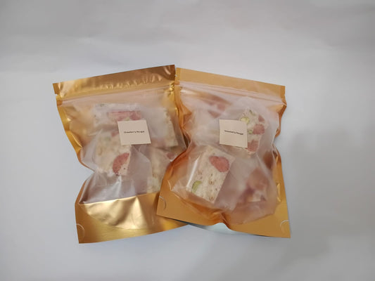 Two packages of food in gold packaging on a white background