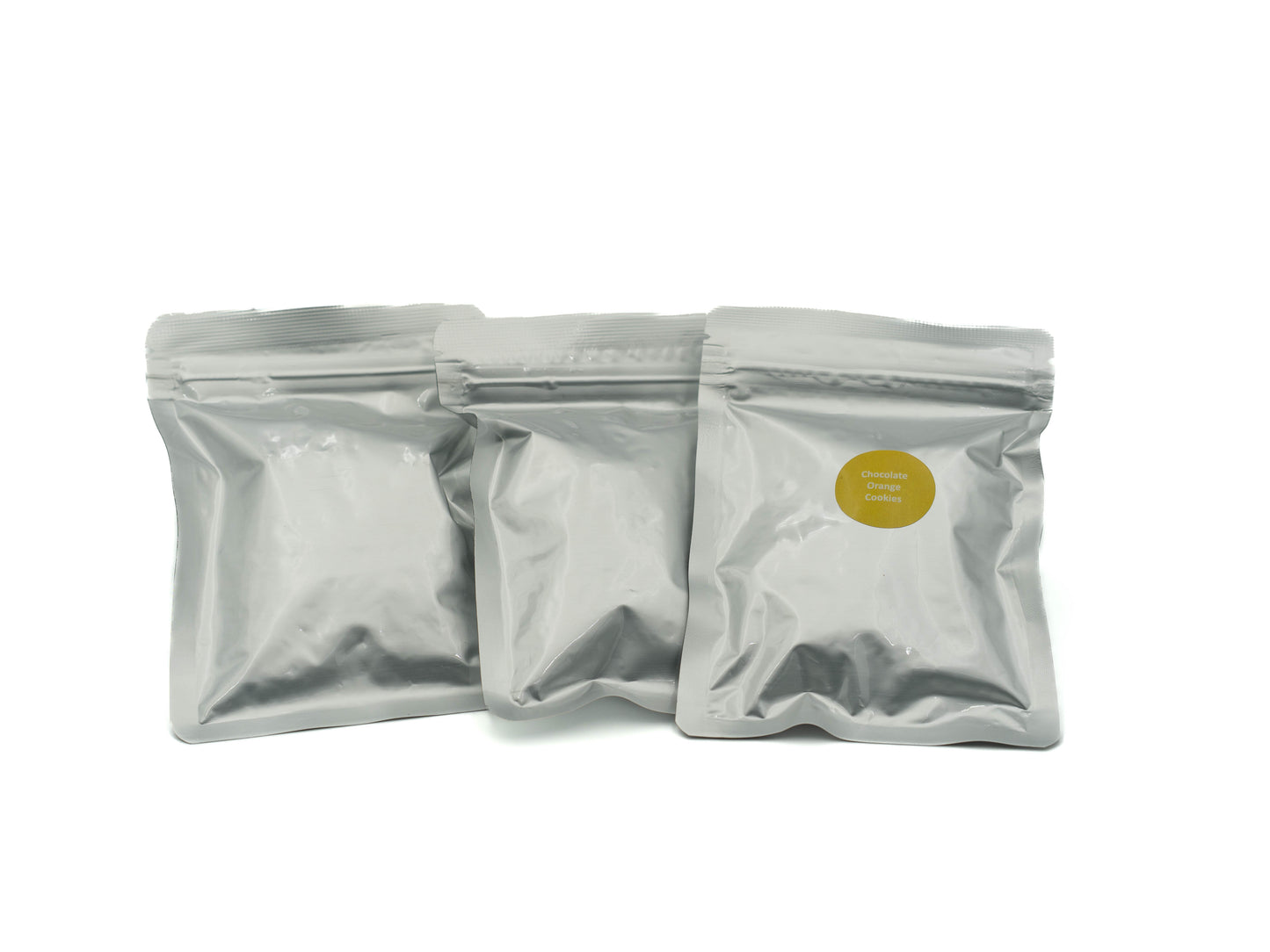 Three silver packaging pouches with a yellow label on a white background