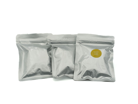 Three silver packaging pouches with a yellow label on a white background